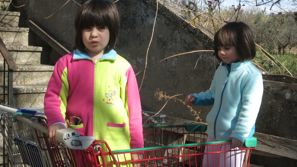 My nieces Allegra and Elettra inside a shopping cart