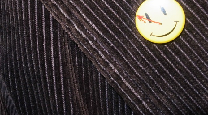 The pin button smile of the The Comedian is on the Kain Malcovich's jacket